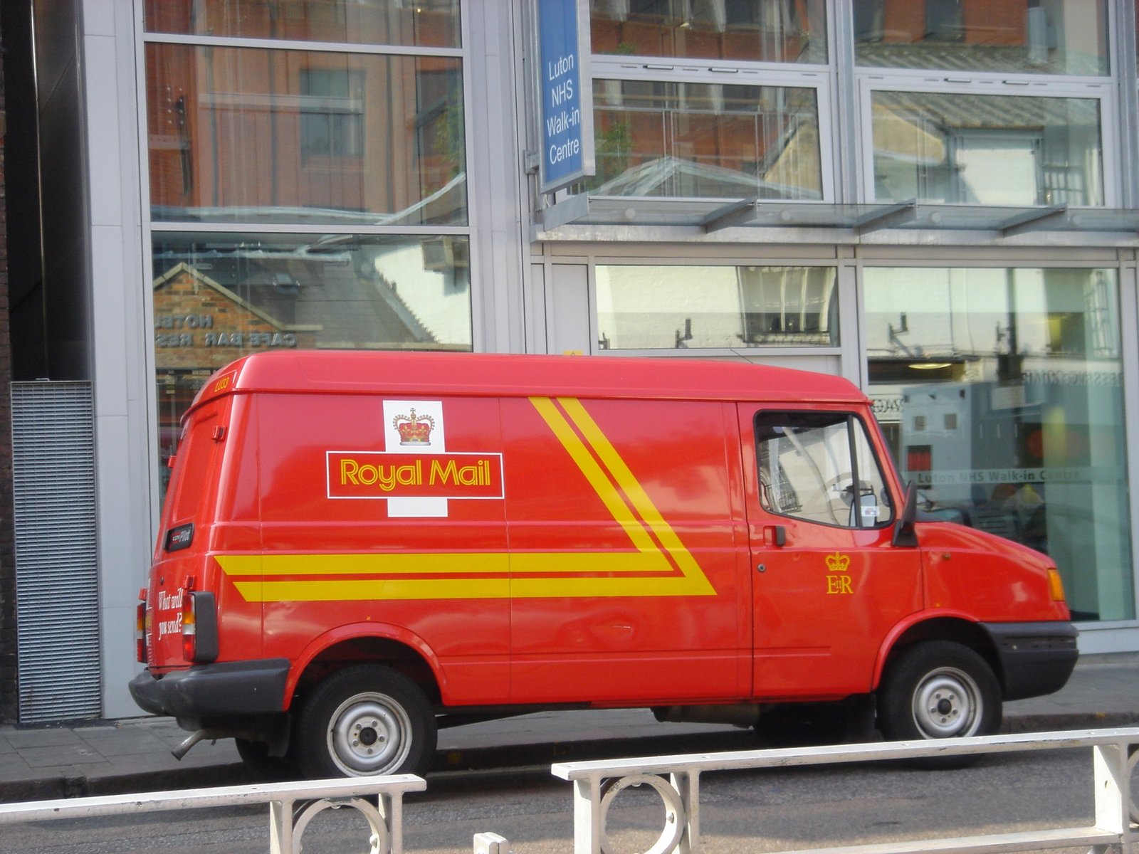 Roter Zustellwagen eines Paketdienstes – meldet sich ein angeblicher Kurier zur Abholung und verlangt Versandkosten im Voraus, ist das typisch für den Fake-Kurier-Betrug auf Kleinanzeigen